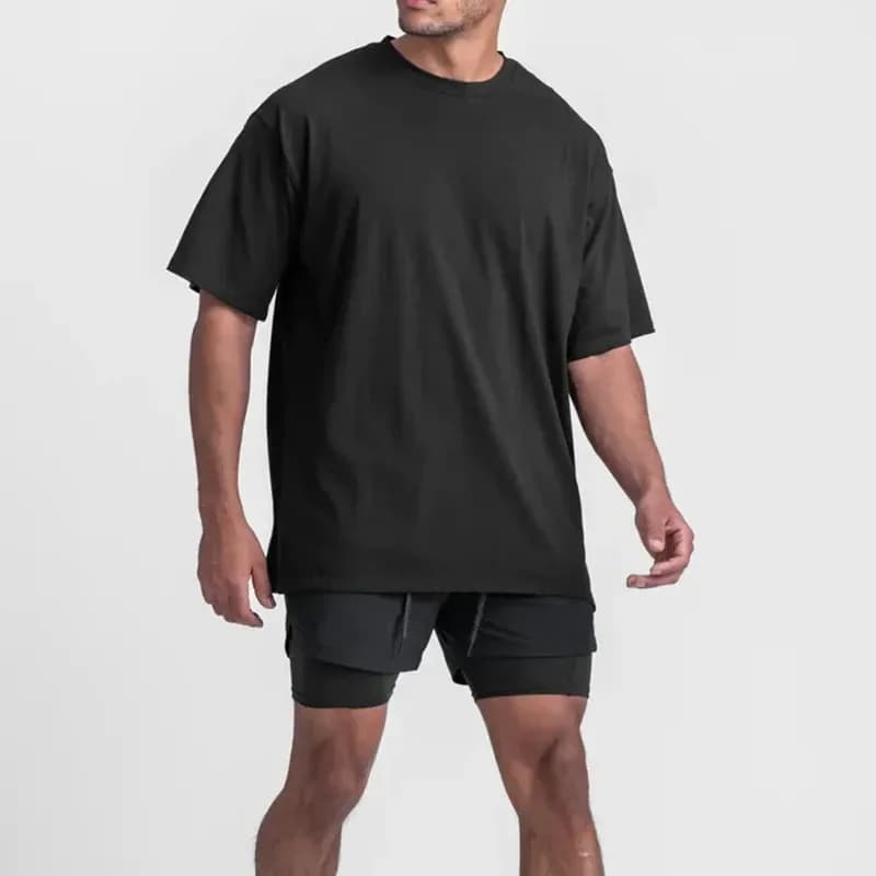 man wearing a black oversized gym t-shirt with training shorts