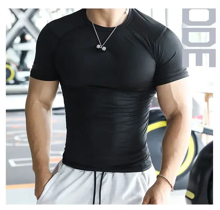 man wearing a black compression gym t-shirt in the gym