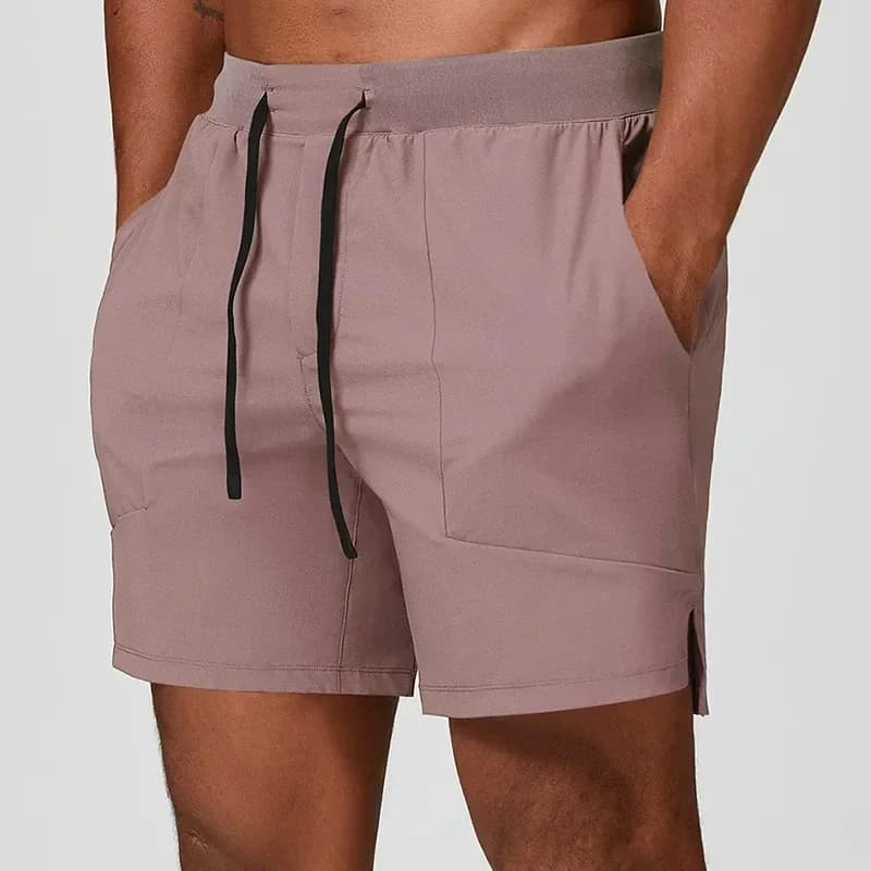 hand in the side pocket of dusty pink stretch training shorts