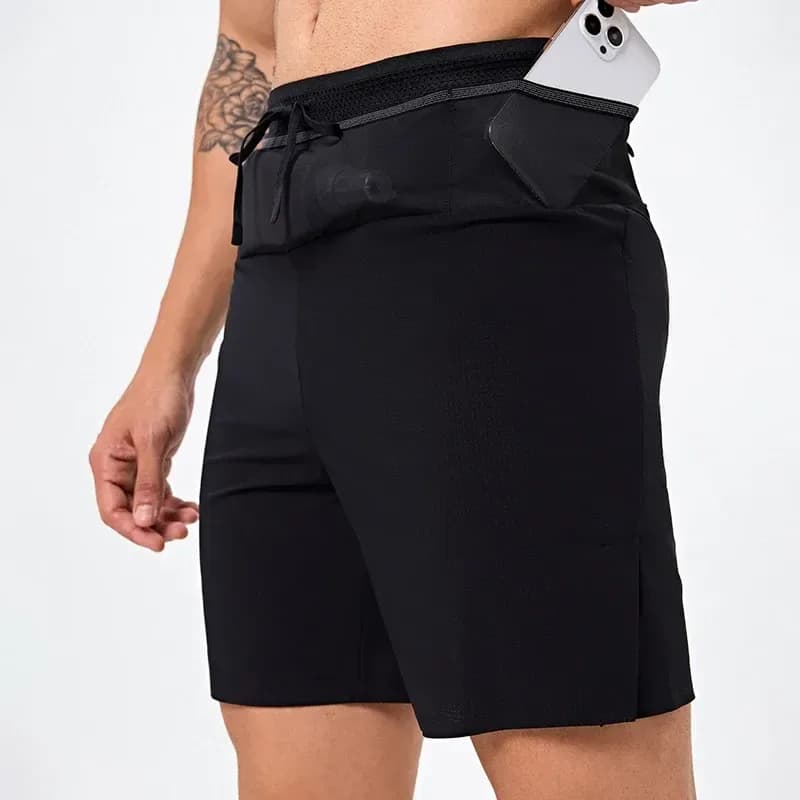 man putting a phone into the waistband pocket of black running shorts