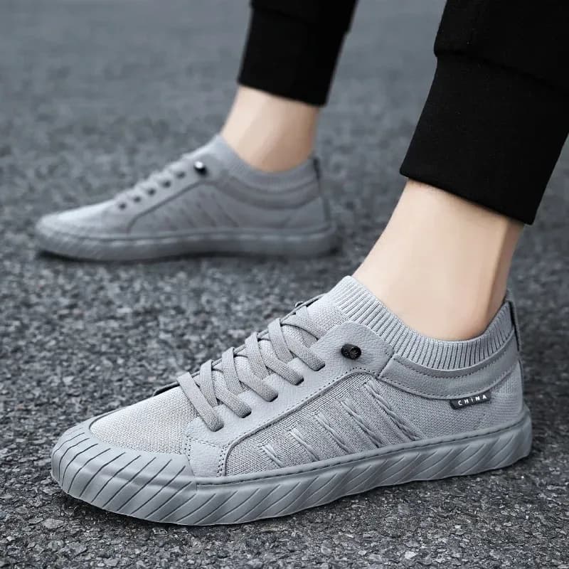 grey men's lightweight mesh sneakers worn with black trousers